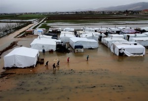 レバノン東部の難民キャンプで、泥水をかき分けて進むシリア難民。１月８日。